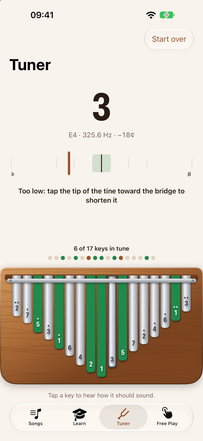 The tuner showing key 3 at E4, 18 cents low, with advice to tap the tine toward the bridge, and six keys marked green as in tune.